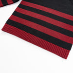 black sweater with red stripes with holes in shoulder