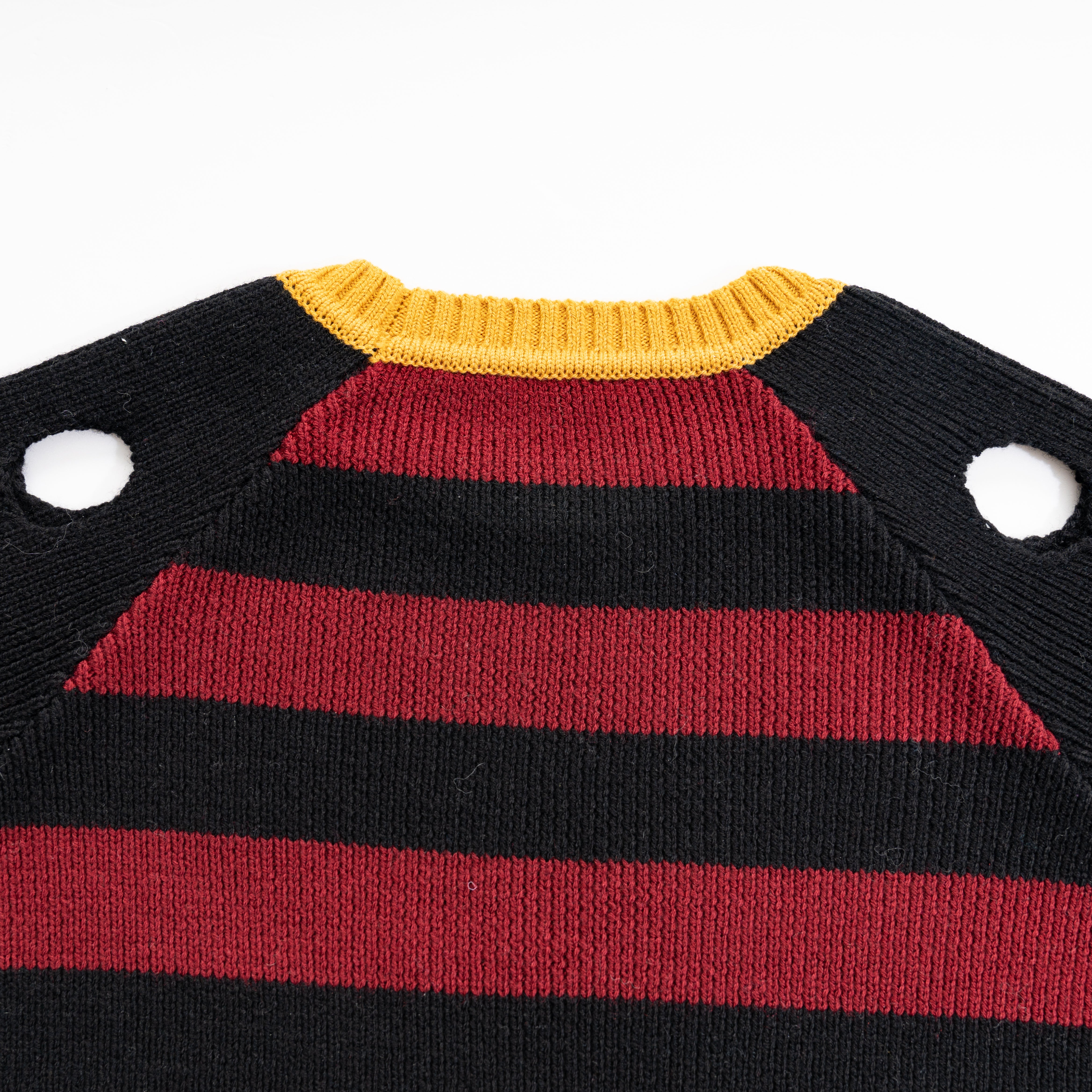 black sweater with red stripes with holes in shoulder